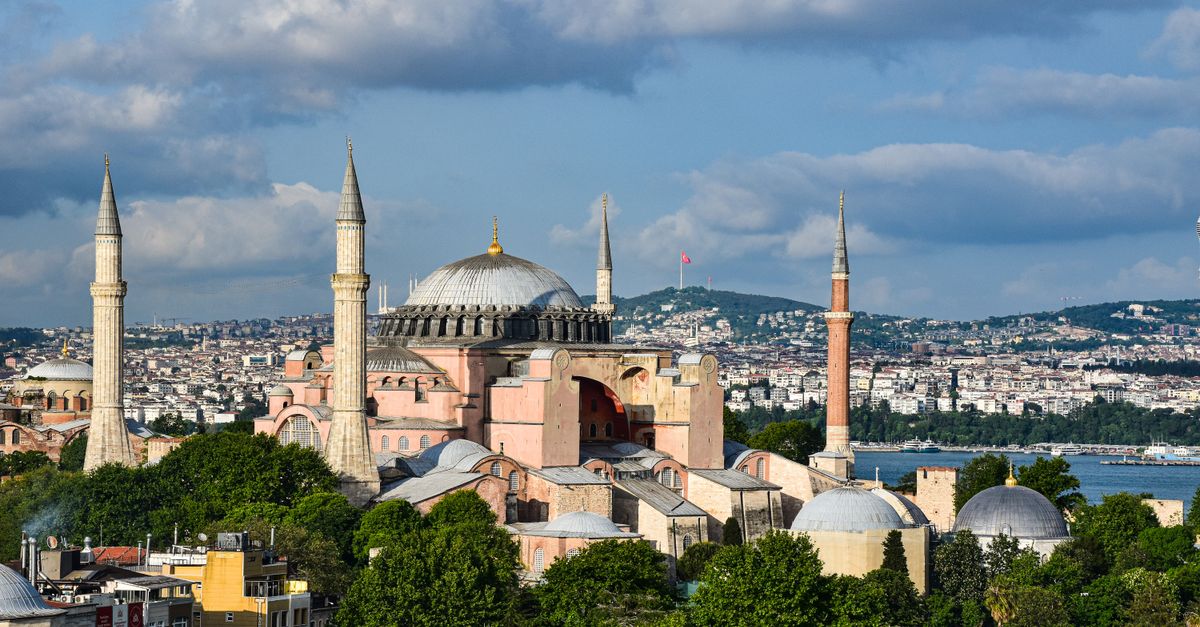 A breathtaking view of Hagia Sophia with Istanbul's skyline in the background under a clear sky.